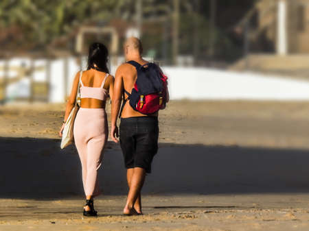 Couple in love walking on the sand of the beach at dusk after a day at the beach