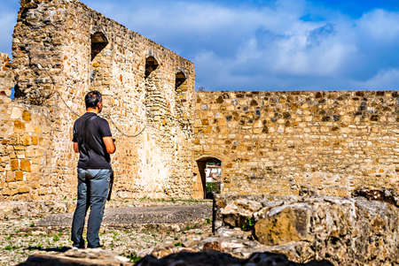 Adult man in black T-shirt in a ruined castle in Torres Vedras in Portugalの写真素材