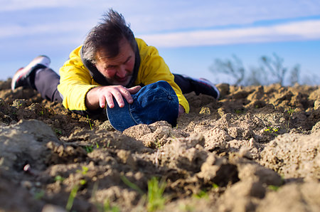 Adult man lying on the ground plowing with his arm outstretchedの写真素材