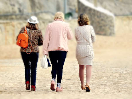 Three ladies walking on the seafront at the Atlantic Oceanの写真素材