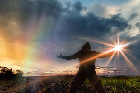 Silhouette of a man at night playing with the light of a flashlightの写真素材