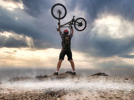 A cyclist in black gear on top of a hill near the oceanの写真素材