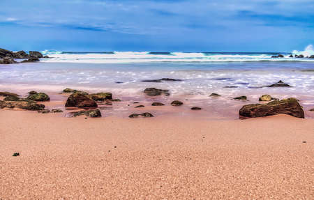 Seascape with rocks on the shore and the sea like silkの写真素材