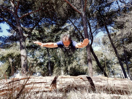 Adult man walking through a city park on a summer dayの写真素材