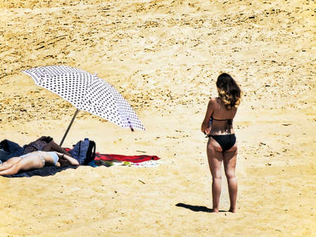 Girl in a black bikini playing volleyball on a beach at the Atlantic Oceanの写真素材
