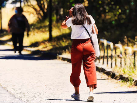 Young woman walking through the park at noon on a summer dayの写真素材