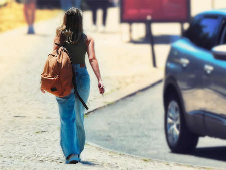 Young woman walking through the park at noon on a summer dayの写真素材