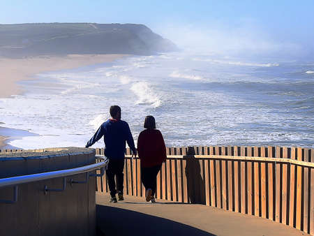 People walking by the ocean on a sunny winter's day