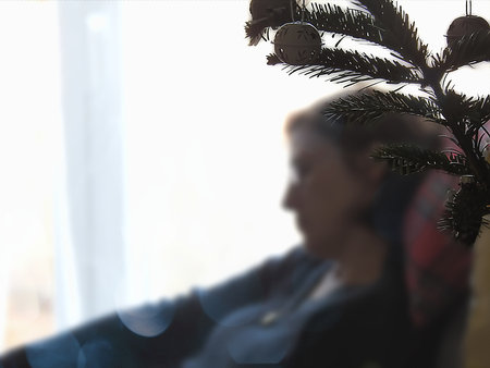 Profile of a woman at the window on a winter's dayの写真素材