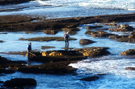 Two men fishing in the rocks