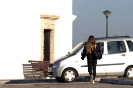 The young blonde walking around the city near a chapelの写真素材