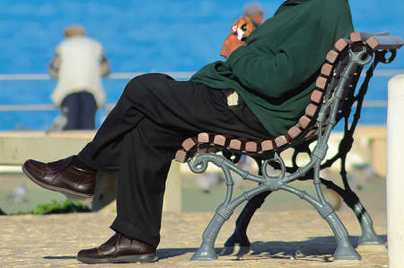 Adult man sitting on the bench with a pack of cigarettes in his hands