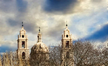 Zoomed church towers with dry branches in the foregroundの写真素材