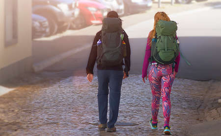 Pair of tourists with backpacks walking around the city