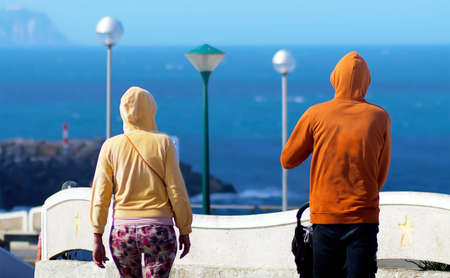 Young family walking on the seafront with their baby
