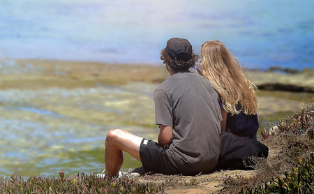 Two lovers on the edge of the ocean looking out to seaの写真素材