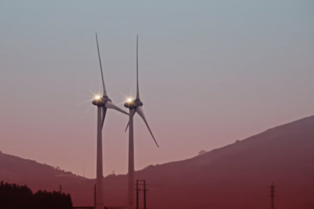 Windmills on a hill at sunrise with zoom