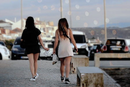 Two women in short skirts walking through a parking lotの写真素材