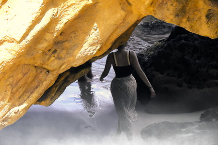 Young woman with skirt and black top on the beach in low tideの写真素材