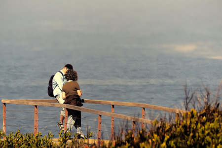 Couple of tourists taking pictures on the ocean shore