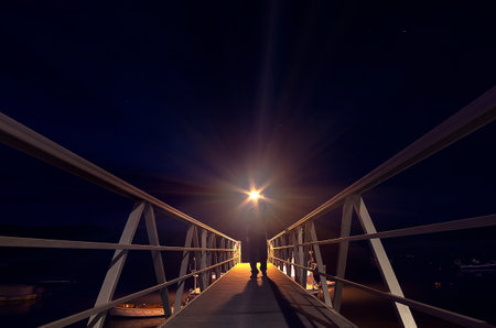 Man at night on a wooden pontoon