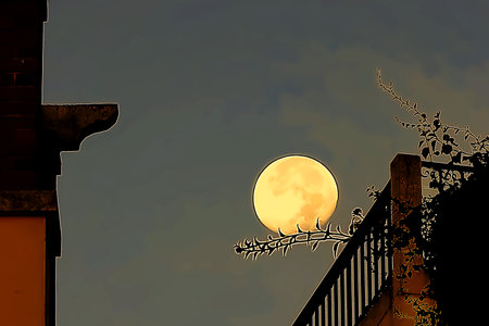 The moon in the morning sky among the buildingsの写真素材