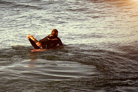 The young surfer alone with the board on the oceanの写真素材