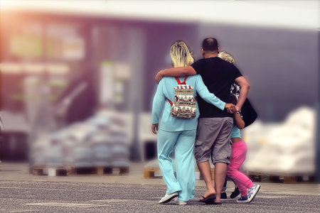 A family hugging on the way to a storeの写真素材