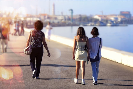 Three people walking on the seafrontの写真素材