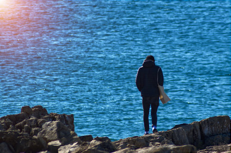Silhouette of a man on an ocean shoreの写真素材
