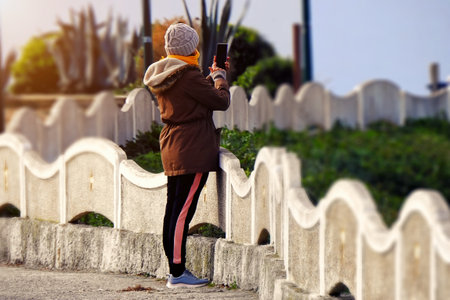 Woman taking pictures with her cell phoneの写真素材