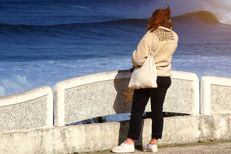 Young woman walking on the beach in the morningの写真素材
