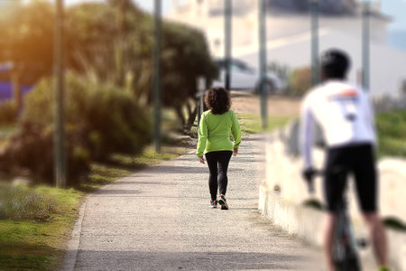 Woman in sports equipment walking in the morningの写真素材