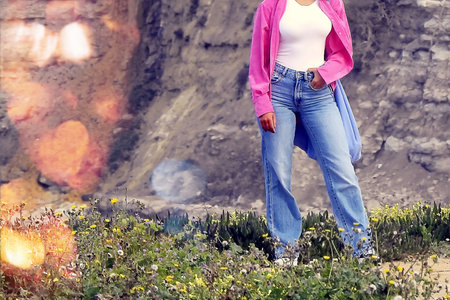 The young woman in the pink shirt posing on the coastの写真素材