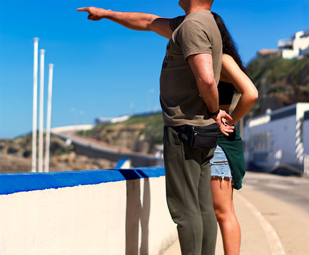 A couple on the cliff facing the oceanの写真素材