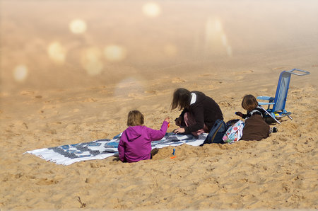 A mother playing with her child on the beach sandの写真素材