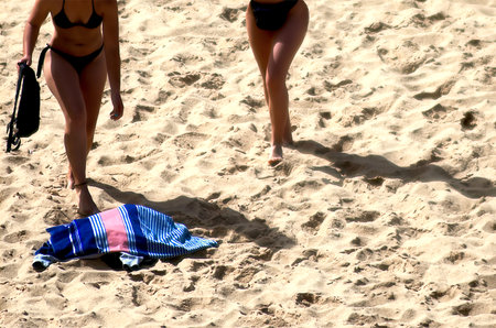 Two lonely women spreading the towel on a beachの写真素材