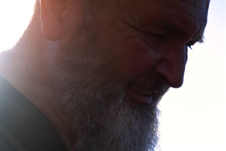 Profile of an adult man with a beard in the light
