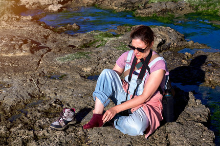 Woman photographing with red hair on the ocean shore