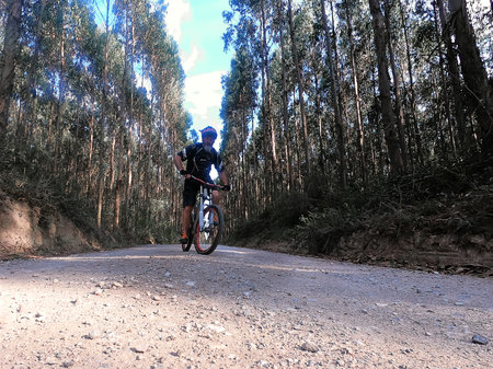 A cyclist with a red helmet on a bicycle at sunsetの写真素材