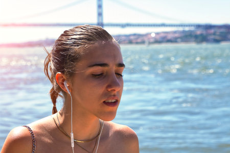Teenage girl with her hair in a ponytail and headphones on the street