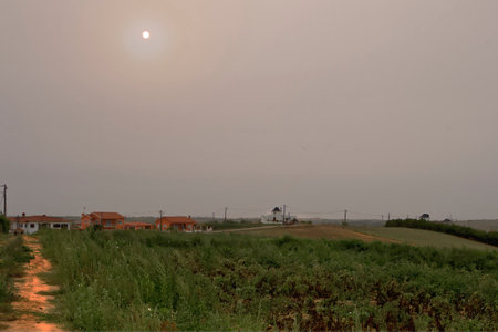 Rural landscape of a field with a few houses on the horizonの写真素材