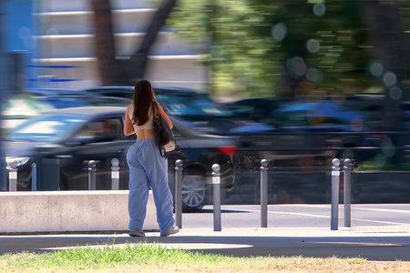 Passersby through a city park on a sunny dayの写真素材