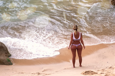 Woman contemplating the ocean from a beachの写真素材