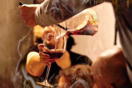 Pouring red wine into a glass with smoke, close-upの写真素材