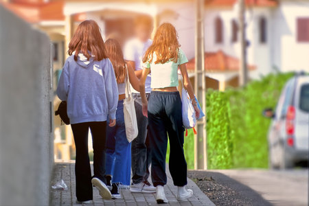 Back view of a group of people walking on the street.
