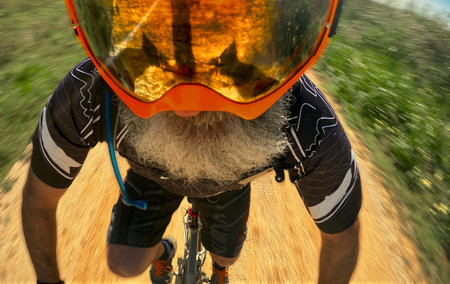 Senior man riding a mountain bike on a sunny day in the countryside