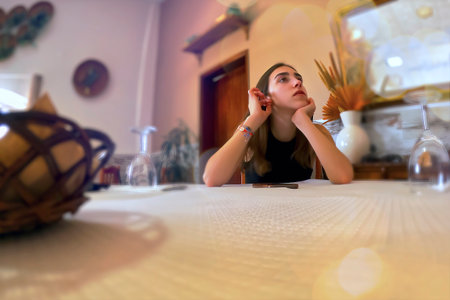 Portrait of a beautiful young woman sitting at the table in a cafe