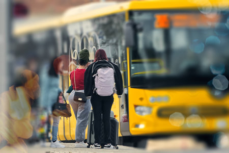 Back view of two girls with backpacks standing in front of bus