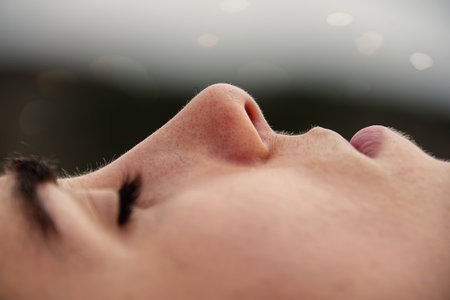 Close up of a young woman's face with closed eyes. Selective focus.の写真素材